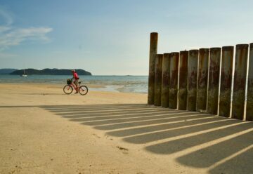 une personne pédalant à vélo sur la plage