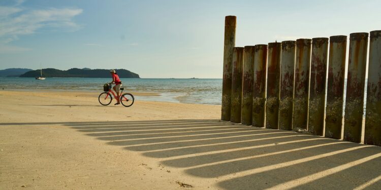 une personne pédalant à vélo sur la plage